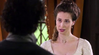 Elizabeth Poldark facing forward sternly talking to Ross Poldark who is facing her