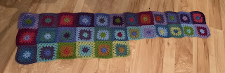 2 and a half rows of multicoloured granny squares. The full rows have 12 squares in them.