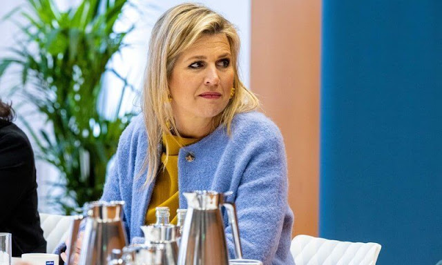 Queen Maxima's outfit (Blue coat, yellow top and pants) is from the fashion house Natan. Rough Studios Bandita mini velvet handbag