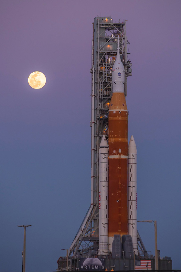 The Full Moon graces the evening sky as the Space Launch System rocket heads toward Launch Complex 39B at NASA's Kennedy Space Center in Florida...on March 17, 2022.