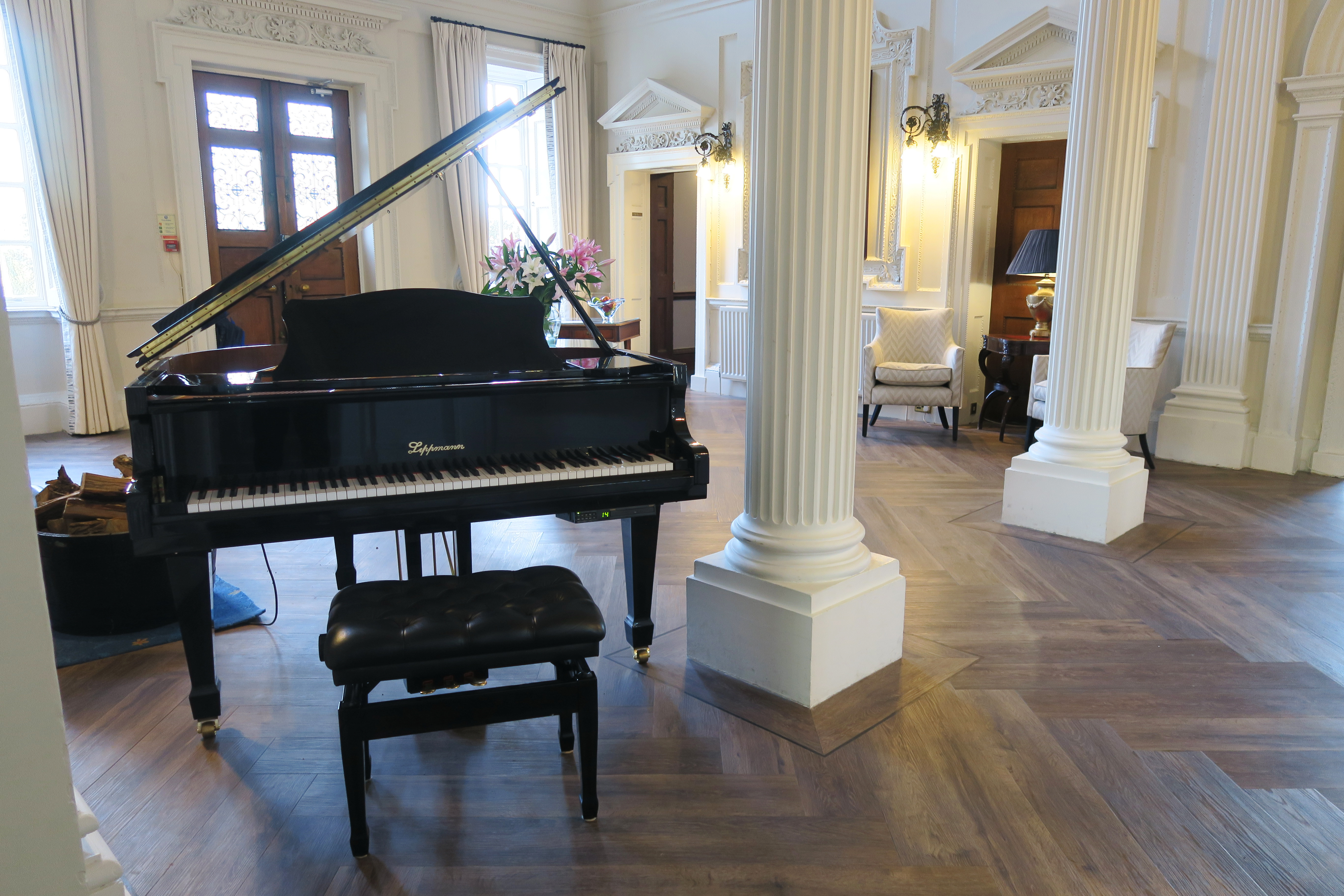 the reception area at Swinfen Hall hotel. In the foreground a large black grand piano can be seen.