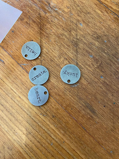 Photo of 4 nickel finish typed word charms.