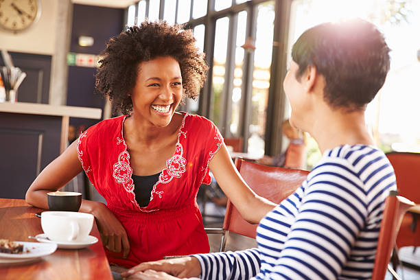 Two friends engrossed in a heartfelt conversation at a cozy coffee shop.