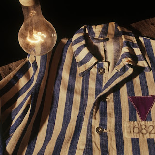 Camisa de un prisionero de un campo de concentración, con la insignia de un triángulo púrpura, identificador de los Bibelforscher (Estudiantes de la Biblia o Testigos de Jehová). Fuente de la imagen: JW.org