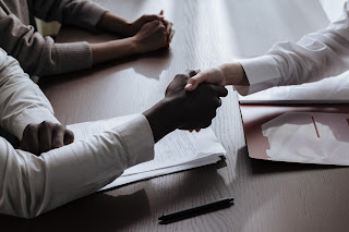 Consider an image depicting a handshake between a podcaster and a representative of a sponsoring brand