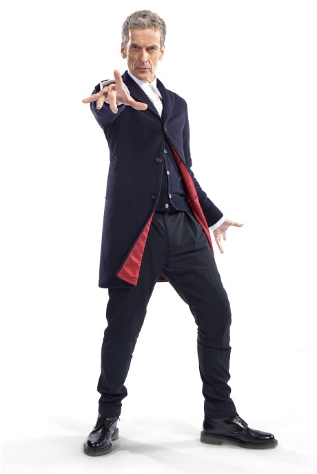 Peter Capaldi as new Doctor in blue jacket with red lining turned out, vest underneath, dark slacks, and black Doc Martens, gesturing at camera with serious look