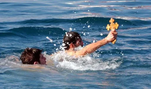 Theophania a priest blessing the waters by throwing a cross in the sea