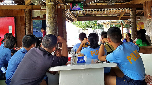 policemen listening to inaugural speech of Rodrigo Duterte, at a restaurant in Palo, Leyte