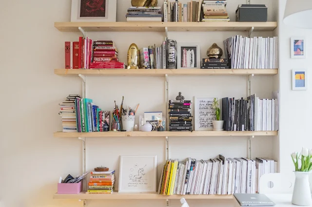 A beautifully arranged bookshelf with a lot of decoration.