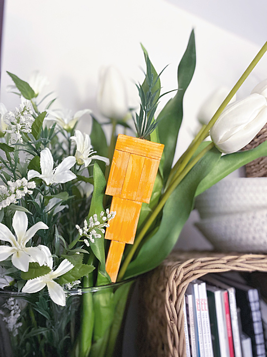 wooden distressed carrot in flowers