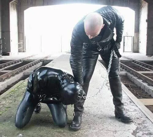 Master trains fully rubbered slave making kneel to kiss feet