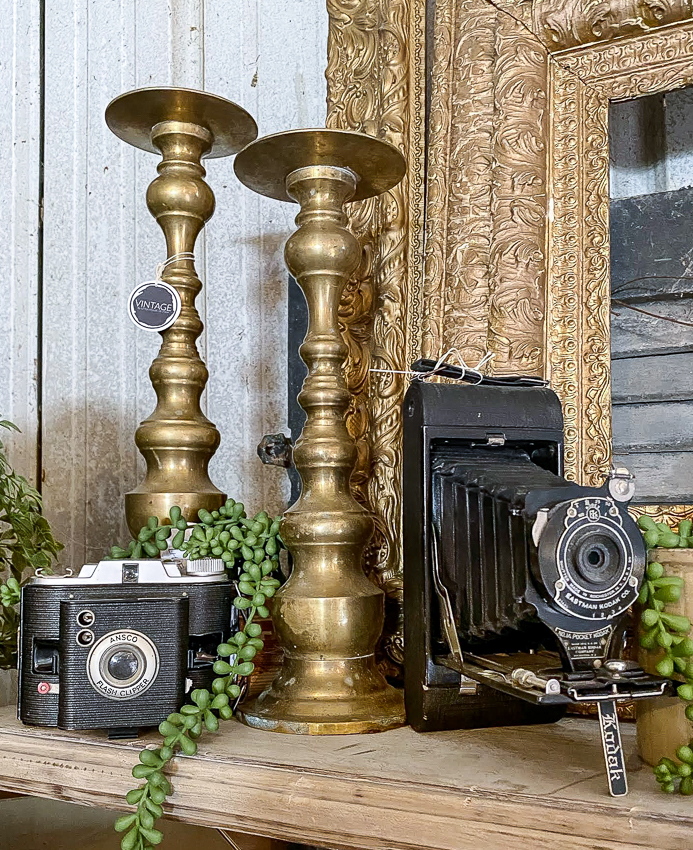 Vintage brass candlesticks and kodak cameras