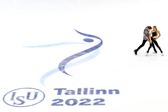 Victoria Sinitsina e Nikita Katsalapov no canto direito da imagem se abraçam. No resto, o logo do Europeu Tallin 2022