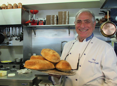 chef de cozinha segurando bandeja com pães artesanais
