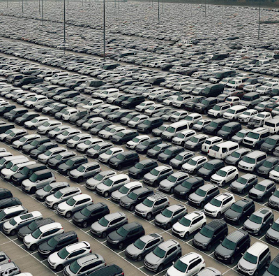 AI generated image of a parking lot full of similar gray, black and white SUVs