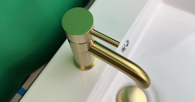 Gold bathroom sink fixture on a white sink.