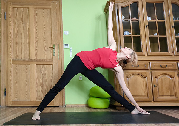 Nauczycielka jogi wykonuje asanę z Ashtanga Joga Utthita Trikonasana