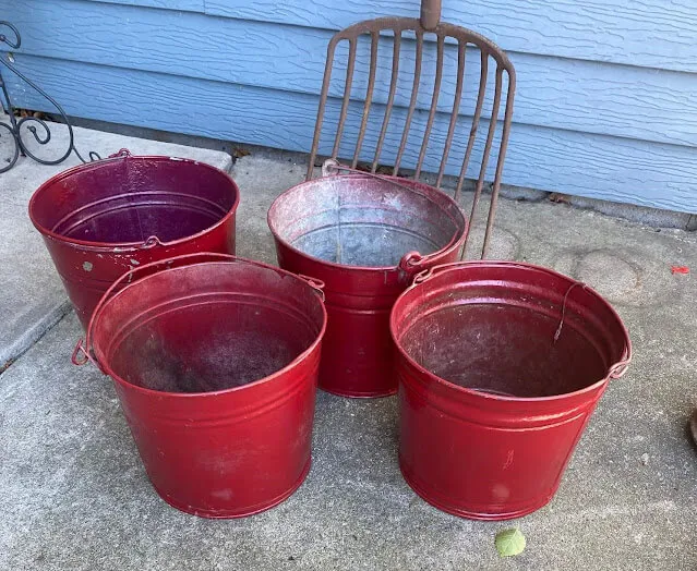 Photo of four red painted metal buckets.