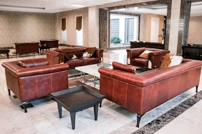 Two Sets of Stylish Brown Leather Sofas Placed in Spacious Room