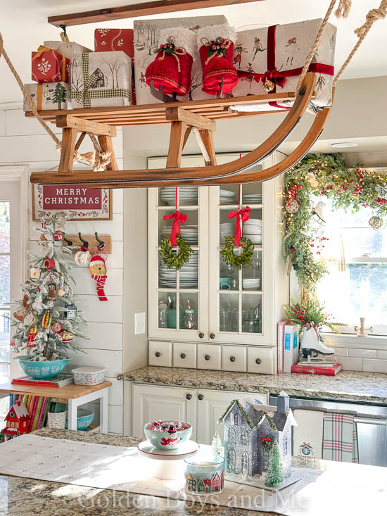 Christmas kitchen with country decor and vintage sled over kitchen island - www.goldenboysandme.com