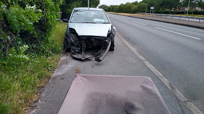 A car left on a shared use path with the front missing after a crash