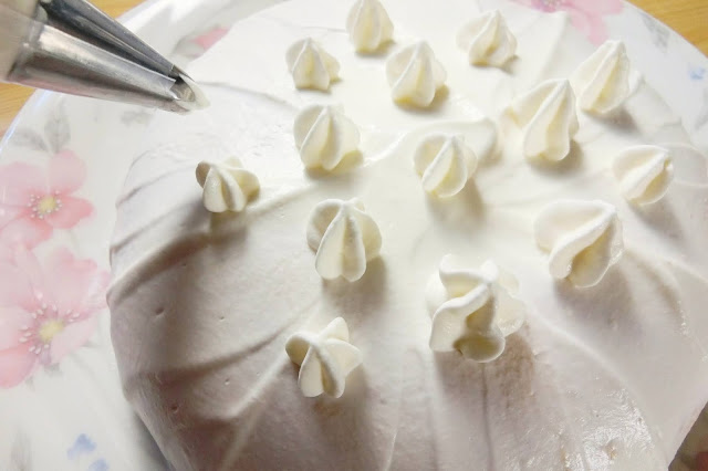 残りの生クリームを少し泡立てて少しかためにしたら絞り袋に詰めて、ケーキの表面に好みに絞り出します。（口金はお好みのもので） 仕上げにストロベリーパウダーを振りかけて完成。