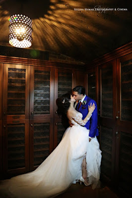 bride kissing groom in wine cellar