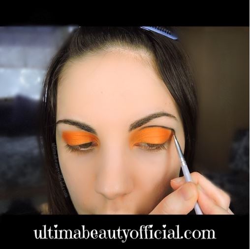 Ultima Beauty tracing black eyeshadow through the crease of the eye