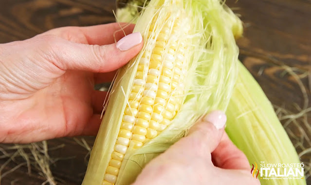 Corn on the Cob in the Oven being shucked