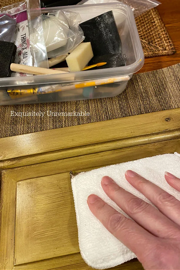 Hand with applicator pad Staining Over Paint On Old Cabinets