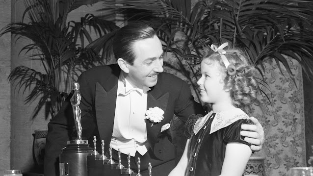 Уолт Дисней получает одного большого и семь миниатюрных «Оскаров» за «Белоснежку и семь гномов» от Ширли Темпл. 23 февраля 1939 года, Biltmore Bowl of the Biltmore Hotel, Лос-Анджелес, Калифорния.