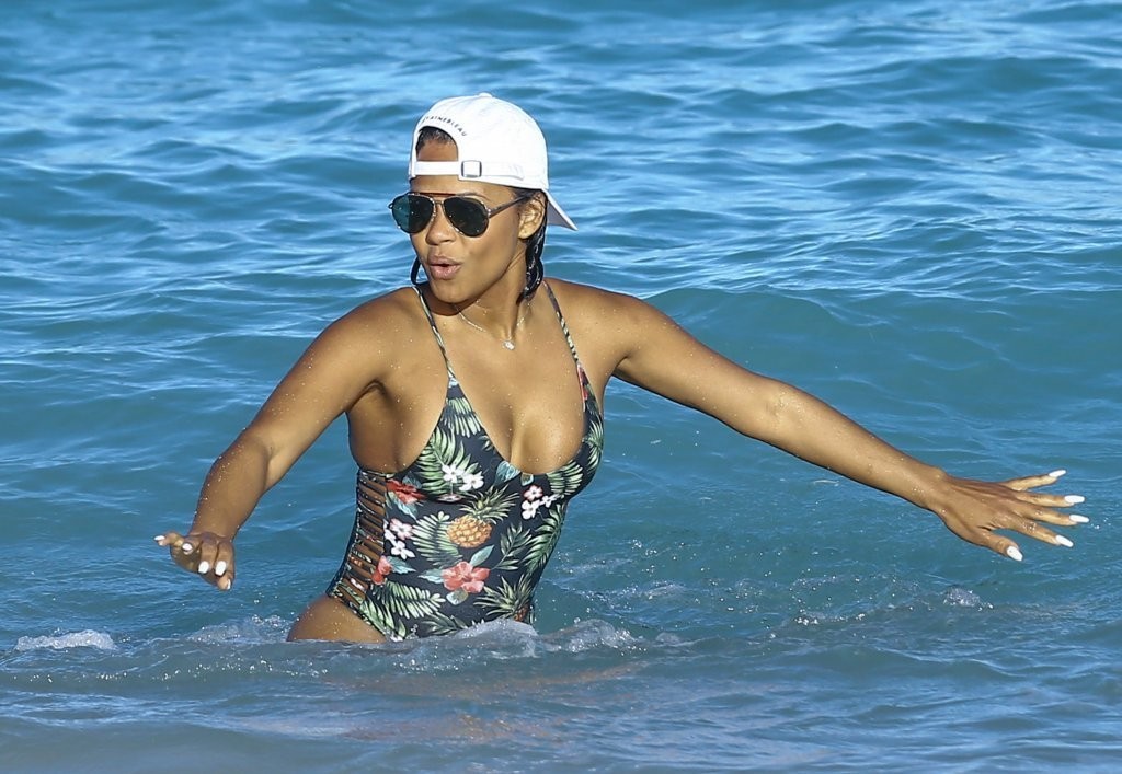 Christina Milian puts her toned figure in a VERY revealing spaghetti strap swimsuit.
