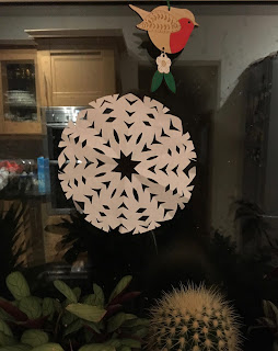 Paper handmade decorations - a robin and snowflake on a window