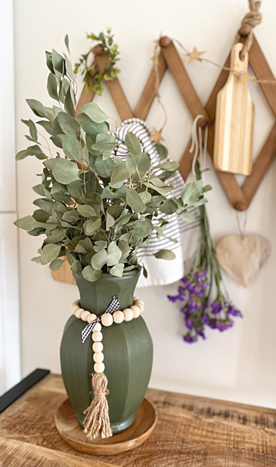 accordion hanger with hanging items and green vase
