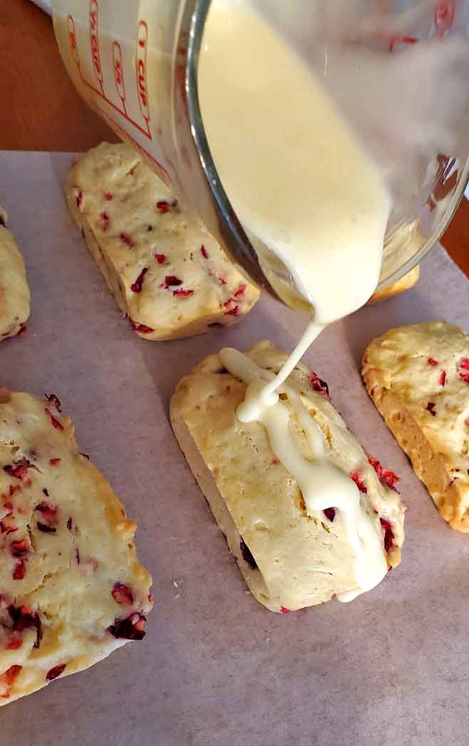 orange icing drizzled over cranberry orange loaves
