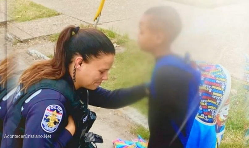 Niño orando con mujer policía