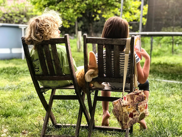 Little boy and girl sitting in a wooden deck chair