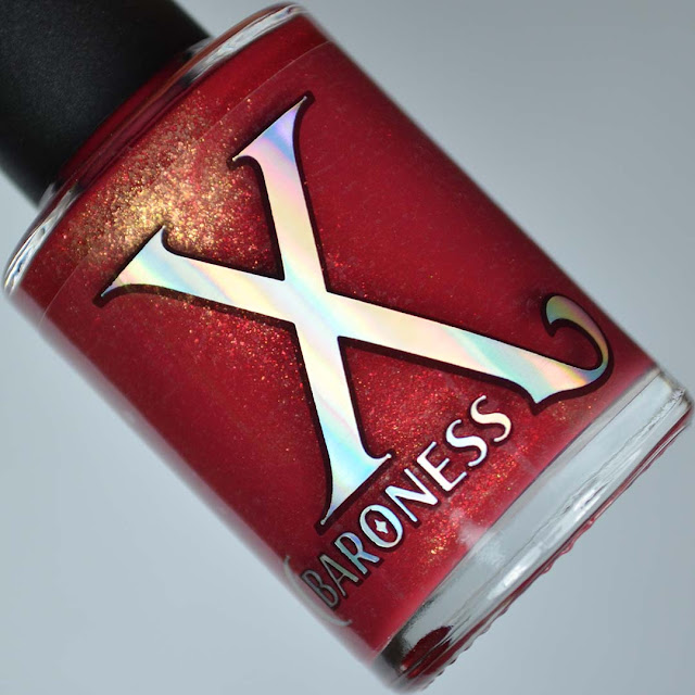 red fluid art polish with gold shimmer in a bottle