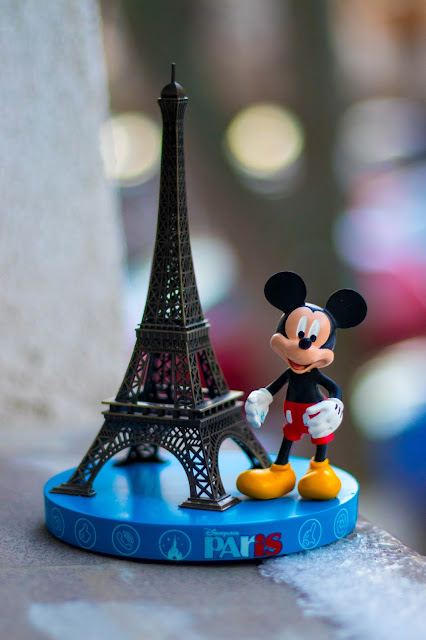 Mickey Mouse figure stood next to the Effiel Tower