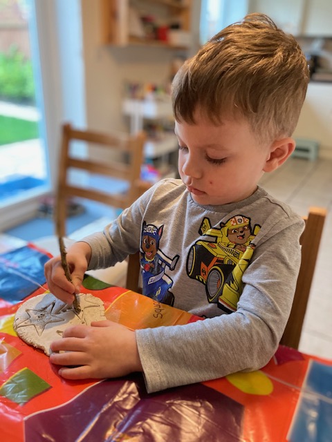 Little boy making clay stars