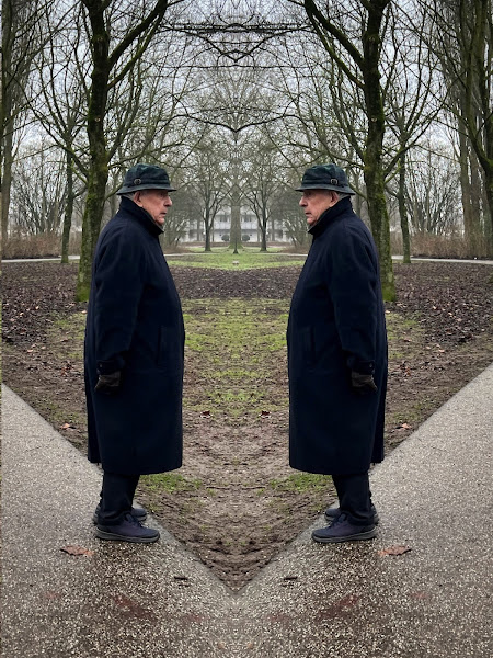 Gespiegelde foto met 2x een goed geklede heer met lange jas en hoedje in park