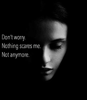 A black and white photograph of a half lit woman's downturned face with a caption saying Don't worry nothing scares me not anymore