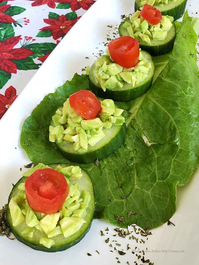 these are appetizers with cucumber and avocado on a white plate