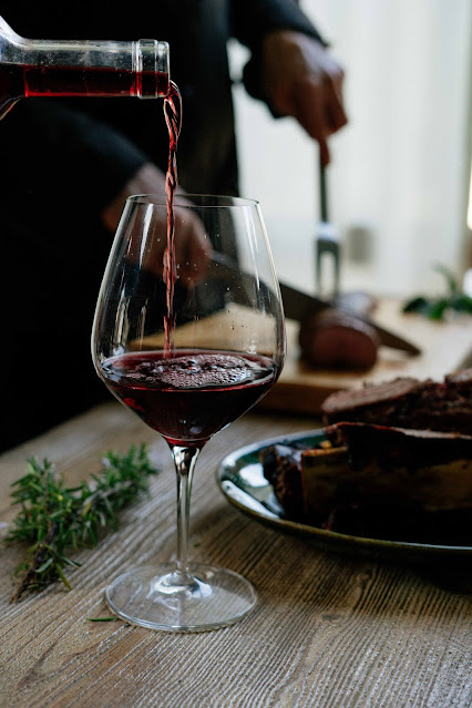 Red wine being poured into glass:Photo by Lefteris kallergis on Unsplash