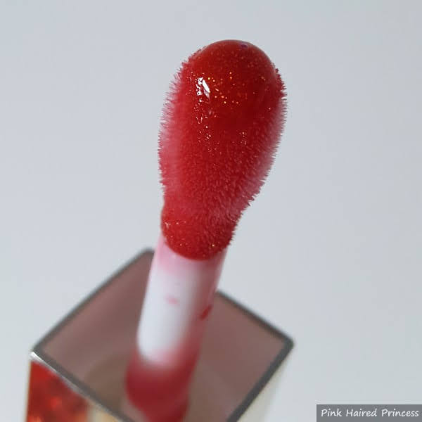 close up of cushioned sponge applicator with red glitter lip oil