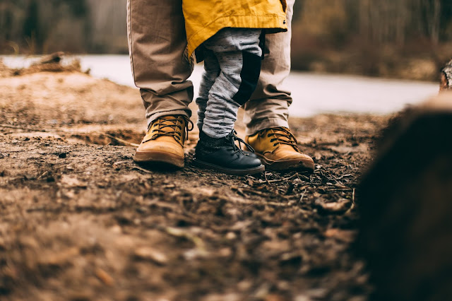 Outdoor shot showing lower halves of adult and child in outdoor clothes