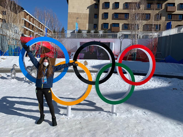 Sabrina Cass em frente aos Anéis olímpicos na Vila Olímpica