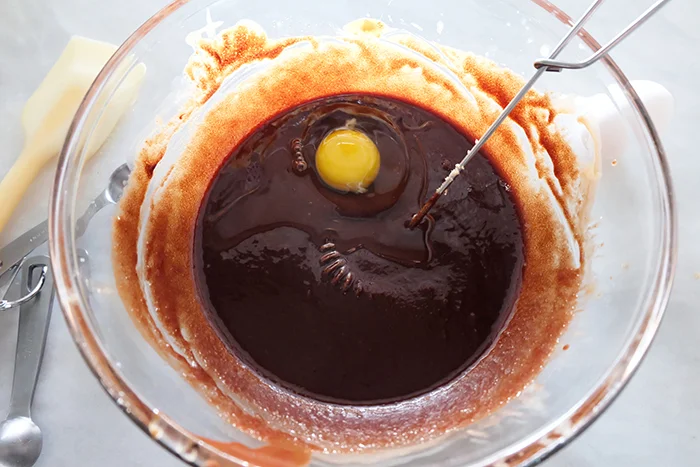 adding eggs to chocolate mixture