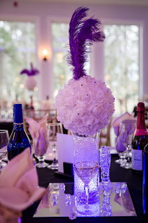 A purple feather centerpiece at a wedding.