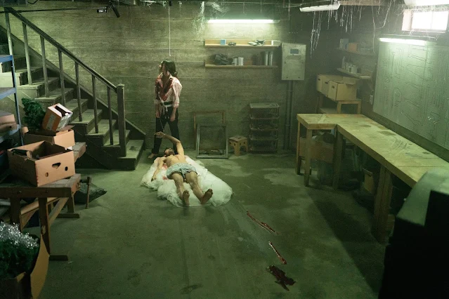 Escena Till Death: Emma (Megan Fox) arrastra el cadáver de Mark (Eoin Macken).